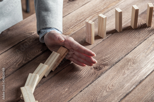Foto Business woman hand stop domino effect