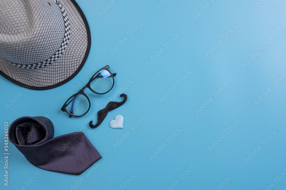 Happy Fathers Day background concept.Decorated hat, eyeglasses,  necktie, mustache light blue heart on light blue pastel background with copy space. Top view, flat lay. - obrazy, fototapety, plakaty 