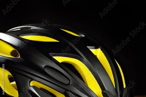  Helmet with yellow foam inserts. Black helmet on a dark background.
