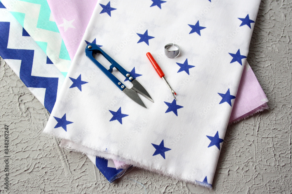 Obraz premium Natural fabric. Graphic cotton. Bright fabrics and sewing tools. Concept - handicraft, making clothes.