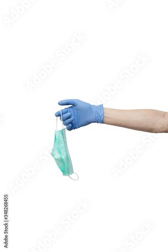 protective medicine mask held in hand isolated on white background. male wearing blue glove holding mask. volunteer, delivery man protection during quarantine of coronavirus pandemic COVID-19, hygiene