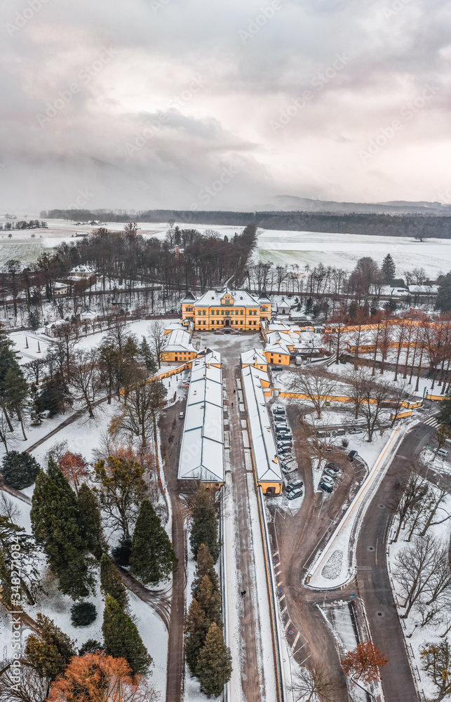 Aerial view of Schloss Hellbrunn covered in snow view of Snow mountain Untersberg near Salzburg outskirts in winter time