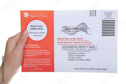 Alameda, CA - May 11, 2020: Young caucasian hand holding mail in ballot. Governor Gavin Newsom just announced California will be a vote by mail only state for the 2020 Presidential election. photo
