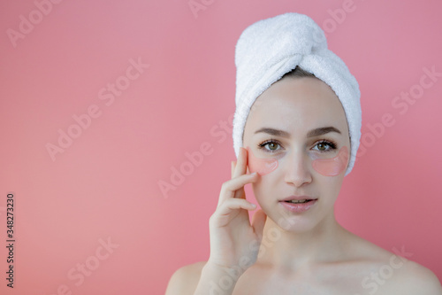 Portrait of Beauty Woman with Eye Patches on pink background. Woman Beauty Face with Mask under Eyes. Skin care, cosmetic product concept with copy space