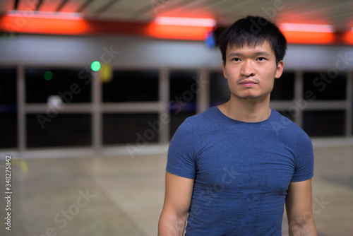 Portrait of young Asian man waiting for train at the subway station © Ranta Images