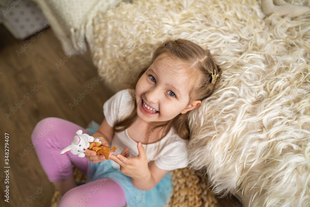 little girl sitting on floor leaning on sofa and fun playing with finger toys little girl sitting on floor leaning on sofa and fun playing with finger toys
