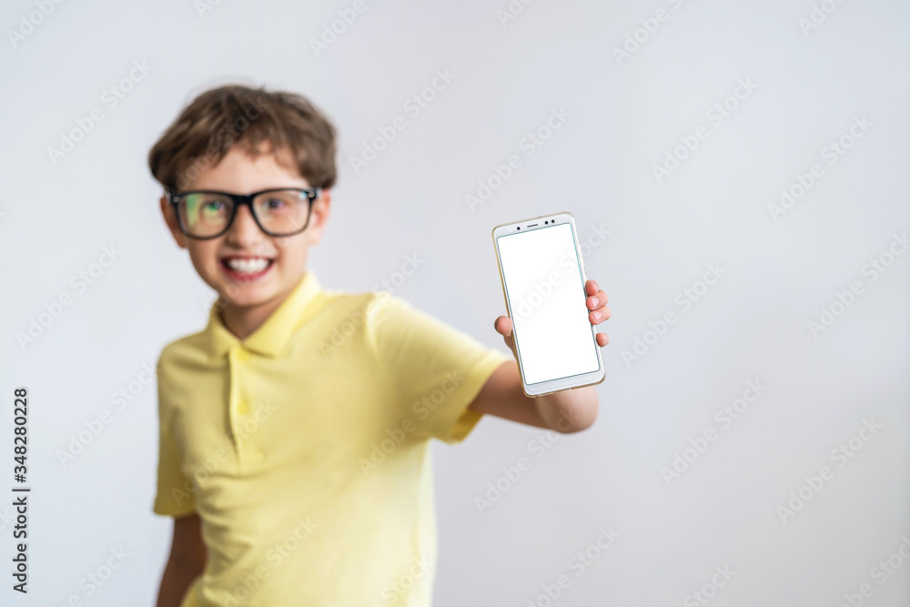 funny smart schoolboy with glasses shows the white screen of his mobile phone. funny smart schoolboy with glasses shows the white screen of his mobile phone.