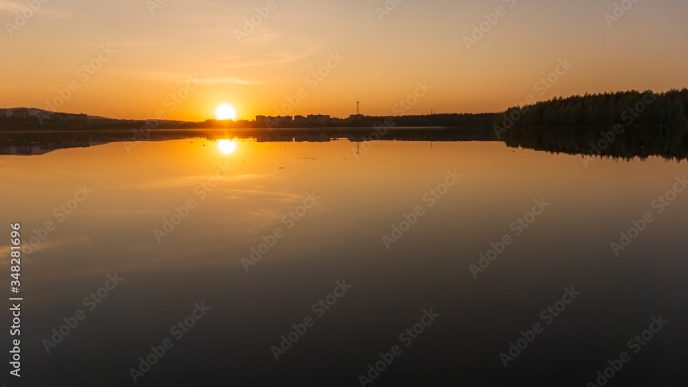 sunset over the lake near the city photo