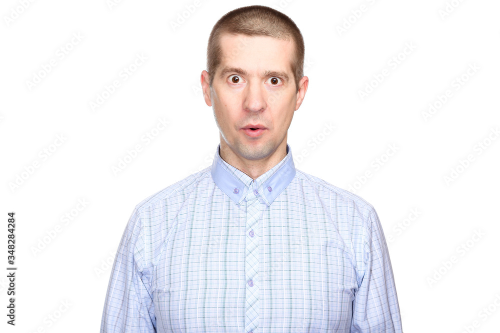 portrait of a joyful surprised man in a classic blue shirt; with eyes wide open with delight and admiration; look into the camera. Isolated portrait of a joyful surprised man in a classic blue shirt; with eyes wide open with delight and admiration; look into the camera. Isolated