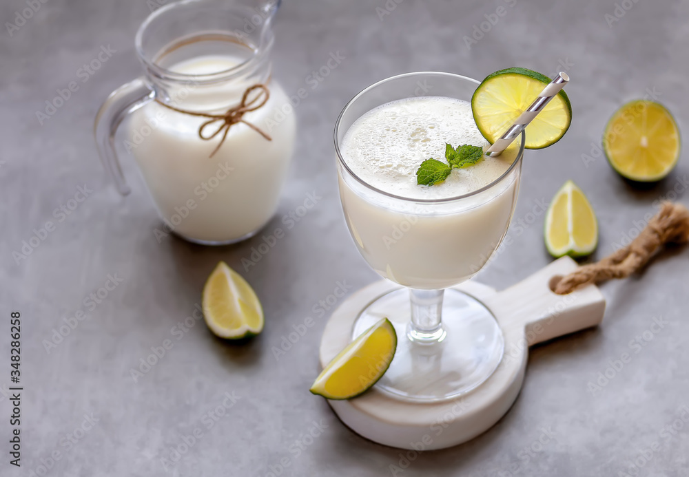 Glass of creamy Brazilian lemonade or limeade decorated with mint and lime slices. Selective focus, copy space. Glass of creamy Brazilian lemonade or limeade decorated with mint and lime slices. Selective focus, copy space.