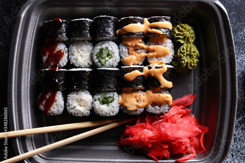 Set of delicious sushi rolls with wassabi and ginger in a box. Wooden chopsticks. Top view. Japanese food. photo