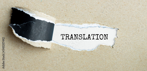 The word TRANSLATION appearing behind torn brown paper. photo