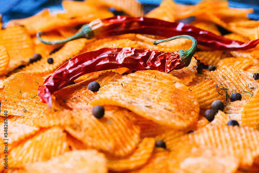 Fluted chips with chili and paprika. Background of chips with spices. Fluted chips with chili and paprika. Background of chips with spices.