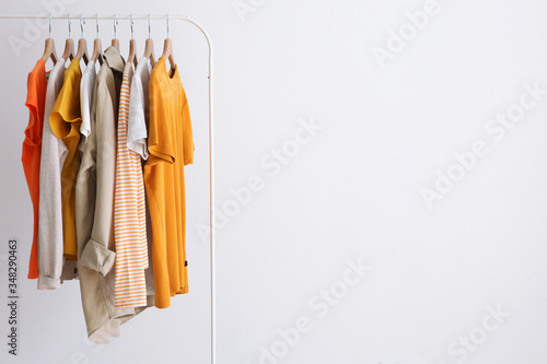 fashion clothes on a stand in a light background indoors. place for text
 photo