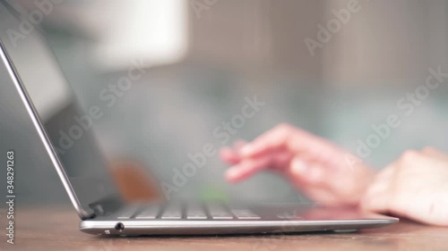 Women's hands open the laptop and lift its lid to start working at home close-up. Remote learning at home via a laptop webcam photo