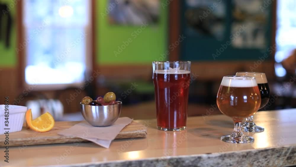 Selective focus of bowl of olives, fresh, lemon juice with slice of lemon and three different wine in various sized glass on counter in a brewery pub Selective focus of bowl of olives, fresh, lemon juice with slice of lemon and three different wine in various sized glass on counter in a brewery pub