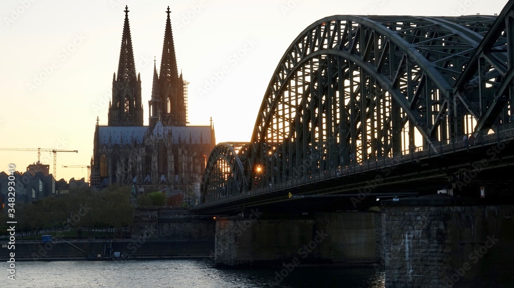 Fototapeta premium Kölner Dom und Hohenzollernbrücke im Sonnenuntergang am Abend