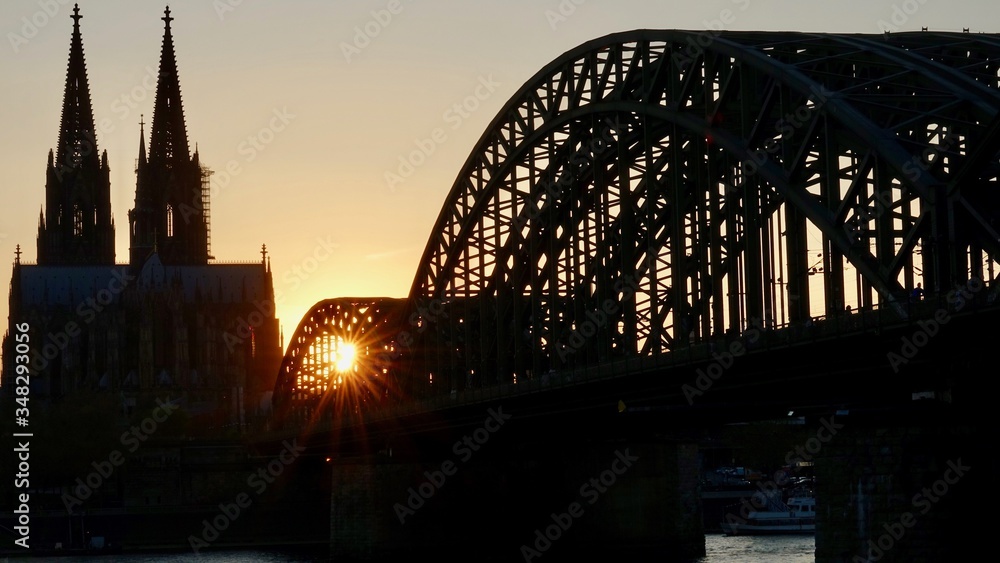 Fototapeta premium Kölner Dom und Hohenzollernbrücke im Sonnenuntergang am Abend