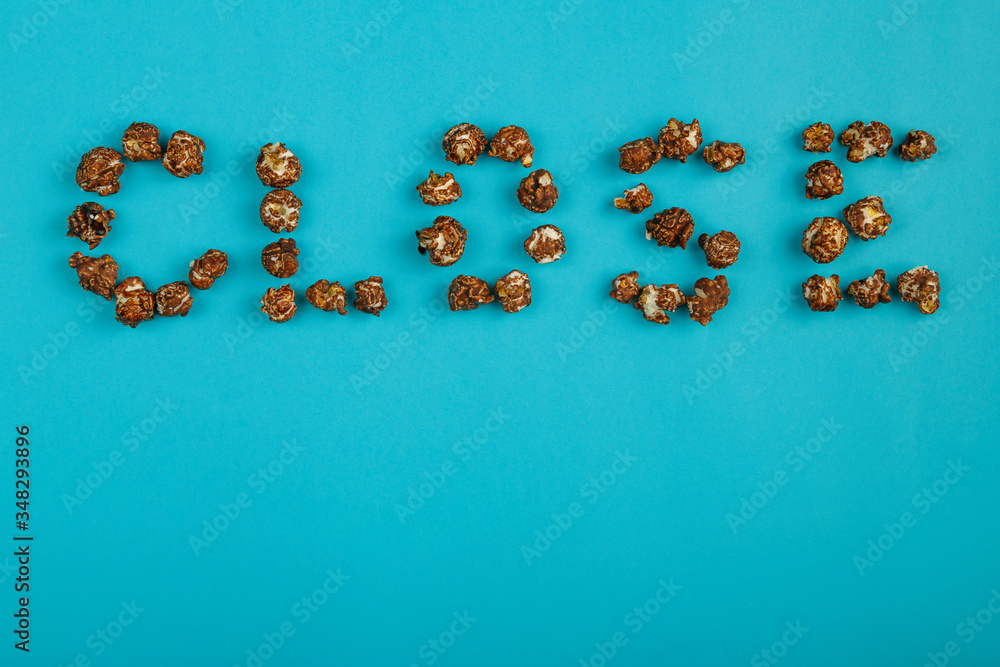 The word closed is laid out from corn kernels on a blue background. The word closed is laid out from corn kernels on a blue background.