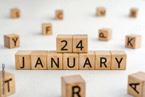 January 24 - from wooden blocks with letters, important date concept, white background random letters around