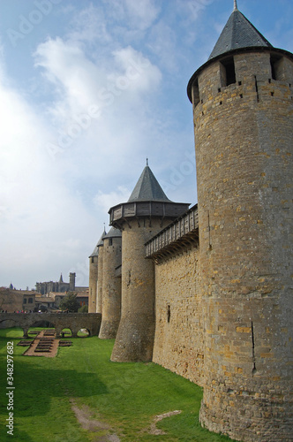 Muralla y torres de defensa de la antigua ciudad medieval de Carcassone, vista del foso principal y casas antiguas photo