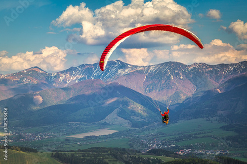 Flying paraglider from the Stranik hill over the mountainous landscape of the Zilina basin in the north of Slovakia..Mala Fatra National Park in the background, Slovakia, Europe..