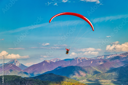Flying paraglider from the Stranik hill over the mountainous landscape of the Zilina basin in the north of Slovakia..Mala Fatra National Park in the background, Slovakia, Europe..