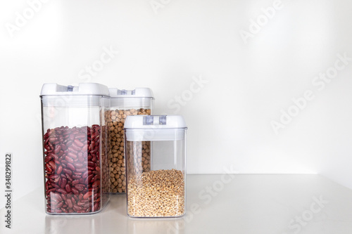 Three Clear Pantry Containers Filled with Non-Perishable Foods-- Dried Beans and Grains