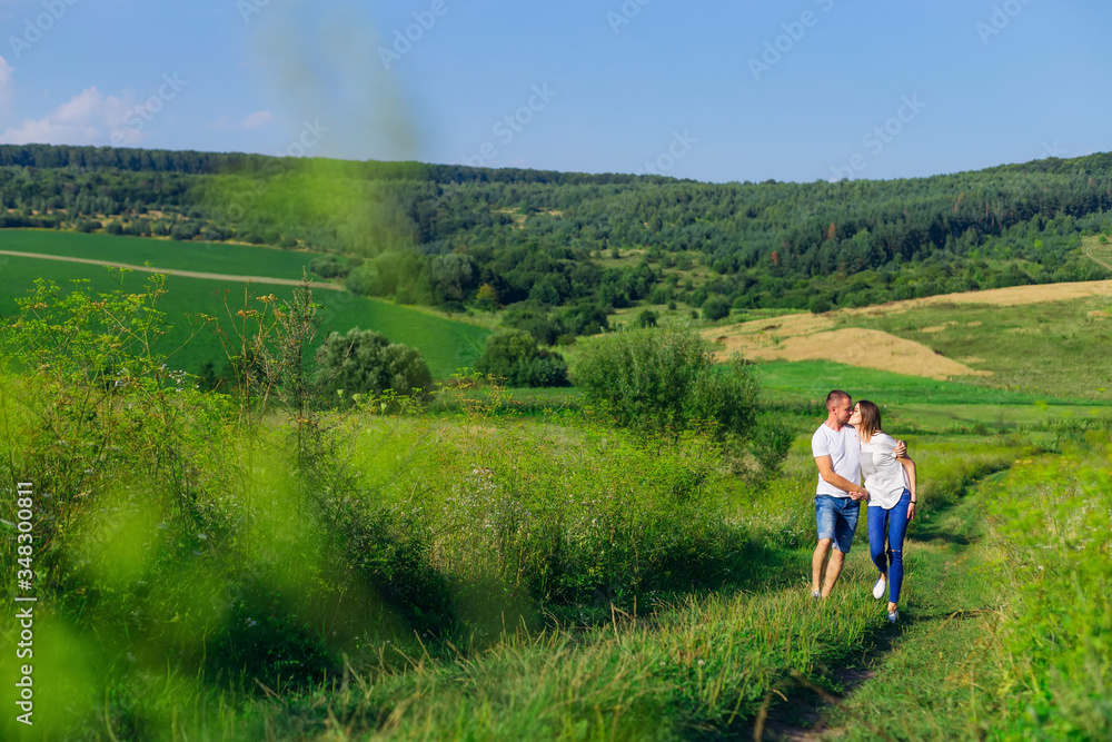 beautiful sunny day. meadow with green grass and forest. couple