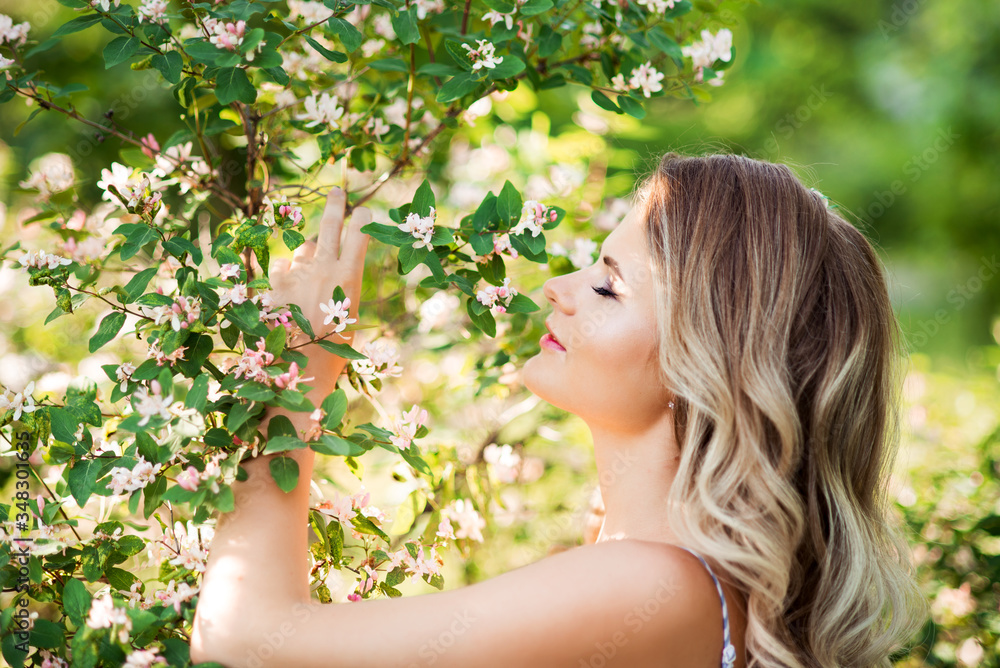 Beautiful young woman in a blooming garden. Close-up portrait of a girl with closed eyes Beautiful young woman in a blooming garden. Close-up portrait of a girl with closed eyes
