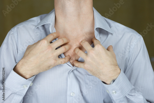 Shortness of breath, stuffy. A man in a shirt touches his chest. Selective focus.