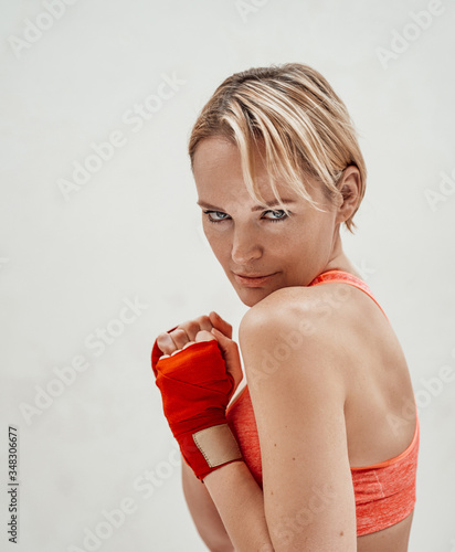 Photo of a beautiful female model posing while preparing her hands for doing martial arts wearing sporty underwear and kumpur tapes photo