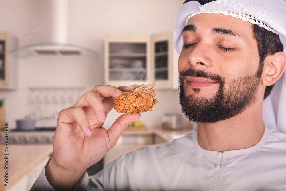 Arab man in the kitchen holding a hot delicious chicken nugget. Arab man in the kitchen holding a hot delicious chicken nugget.