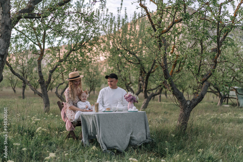 Happy family in the garden at breakfast with milk, cheese and pa photo