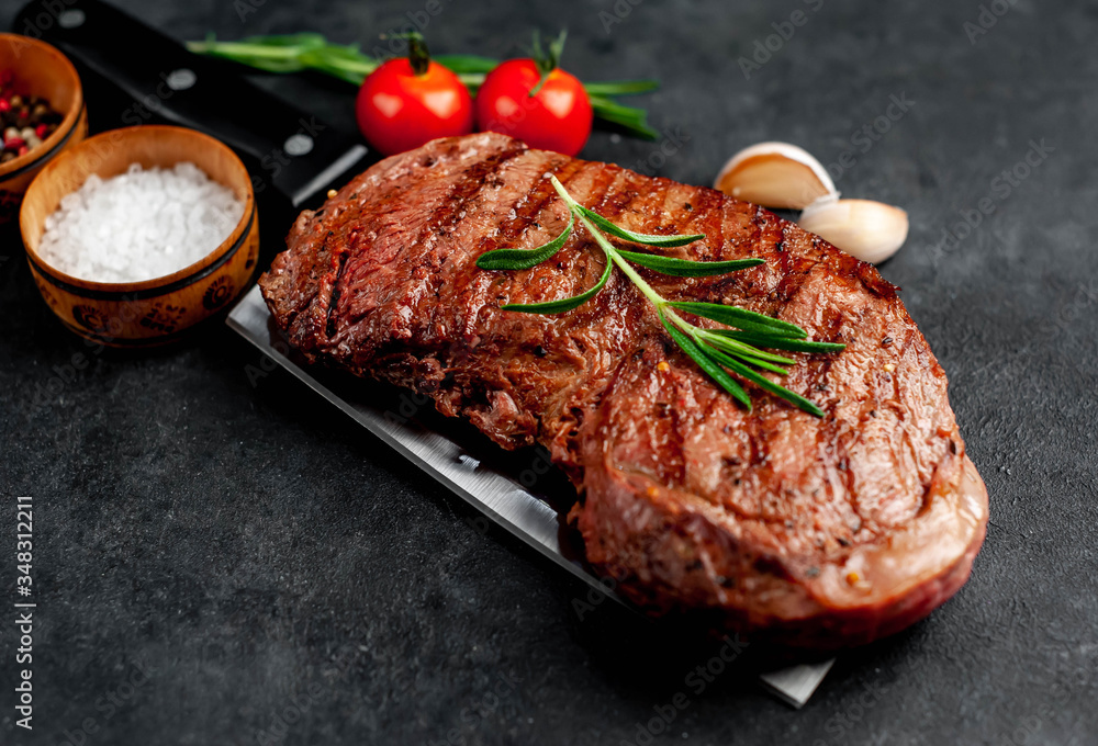 grilled beef steak with spices on a knife on a stone background grilled beef steak with spices on a knife on a stone background