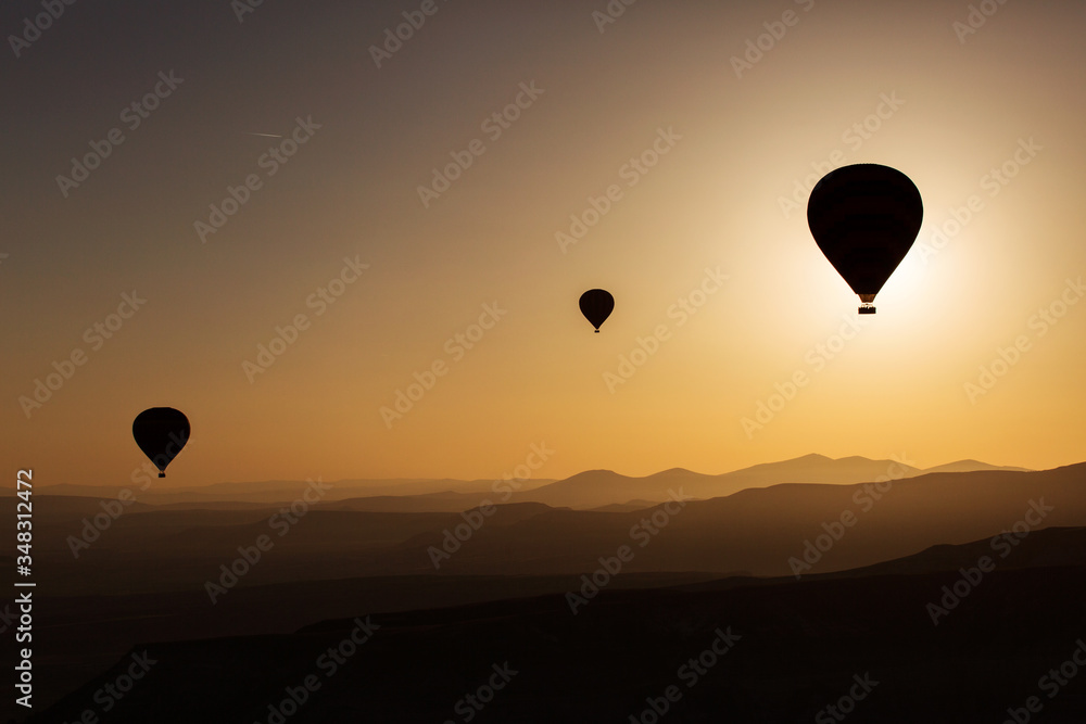 Silhouette of balloons with sunrise in background, aerial view Silhouette of balloons with sunrise in background, aerial view