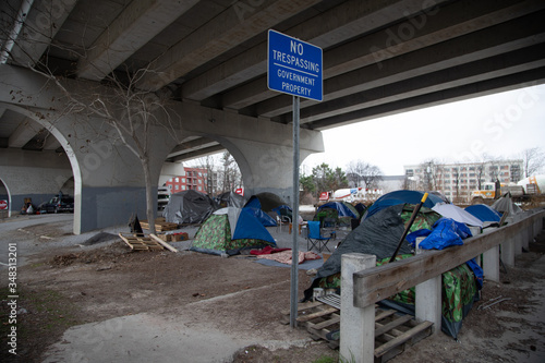 Homeless under a bridge with sign