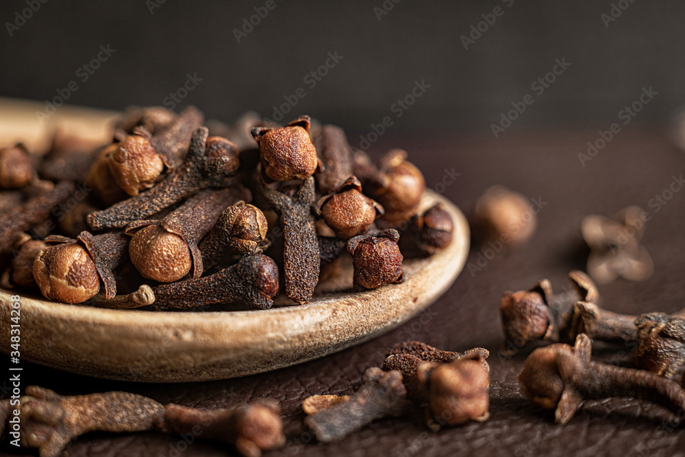 Spice clove in a wooden spoon, close up. Spice clove in a wooden spoon, close up.