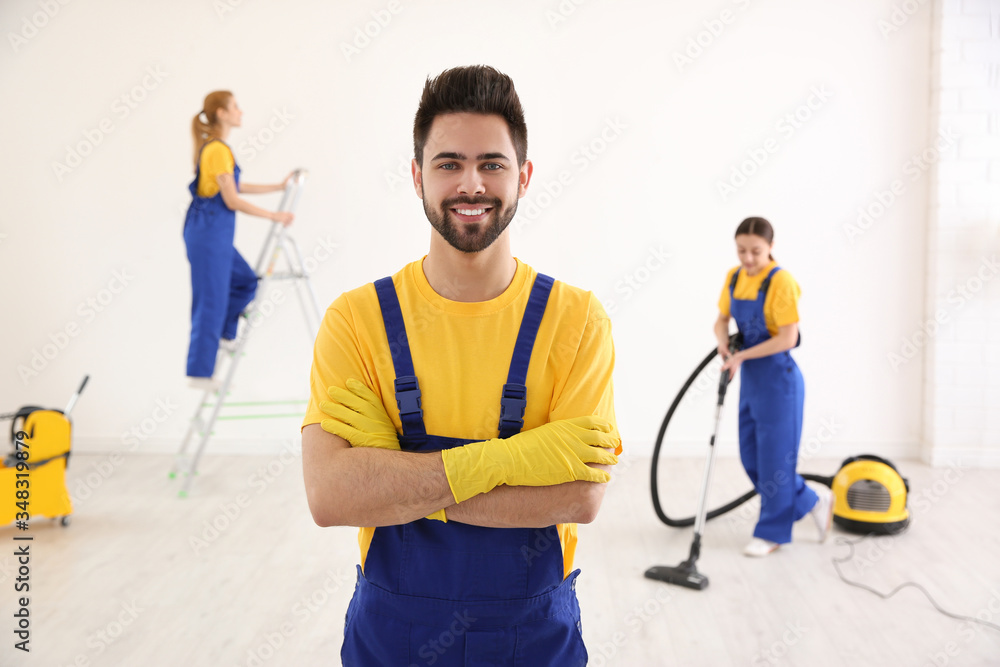 Professional janitor in uniform indoors. Cleaning service Professional janitor in uniform indoors. Cleaning service
