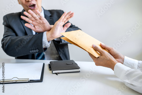 Anti Bribery and corruption concept, bribe in the form of dollar bills, consultant refuse receive money from business woman while making deal to agreement a real estate corporate contract