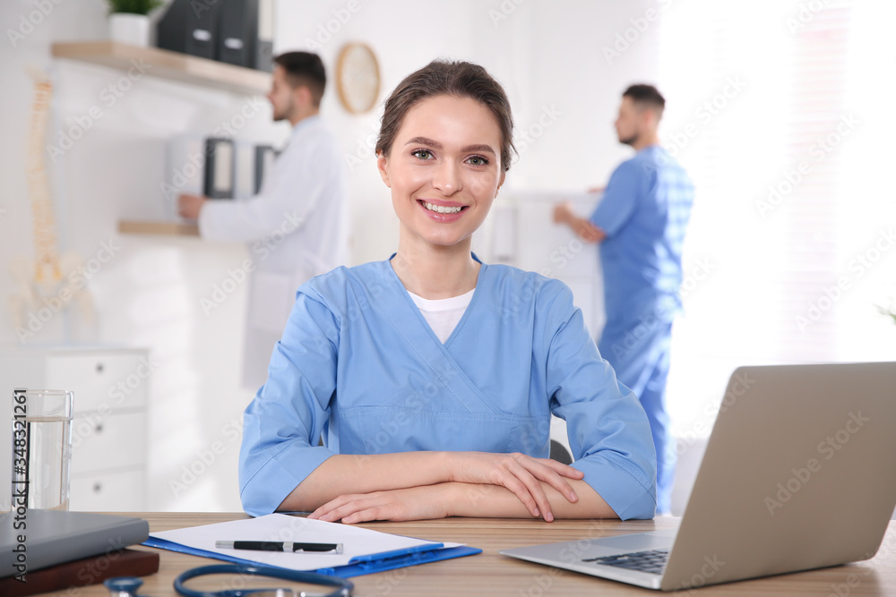 Portrait of female doctor at table in modern clinic Portrait of female doctor at table in modern clinic