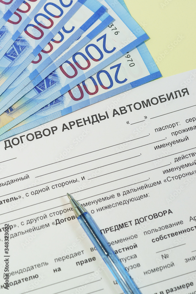 Obraz premium The signing of a bilateral agreement of renting a car from an individual. Russian rubles, a pen and the text 