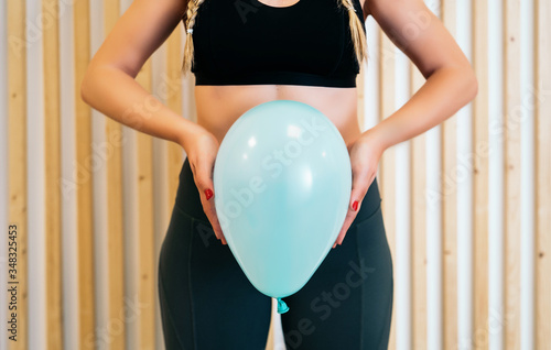 Close up of a young woman holding a balloon to explain the diaphragm zones, core and pelvic floor. Pelvic floor exercises explained