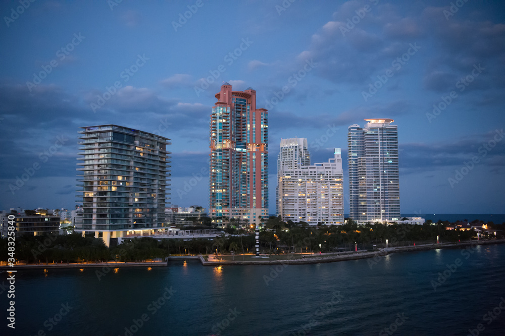 Naklejka premium Miasto zasypia. Koncepcja życia nocnego. Pejzaż po zachodzie słońca. Nowoczesne wieżowce. Wygląd wizualny obszaru miejskiego. Wielkomiejskie życie. Architektura centrum dzielnicy biznesowej ciemne tło nieba