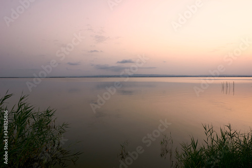 Sunset on the big lake, from the reeds, green, golden colors, calm waters, reflections