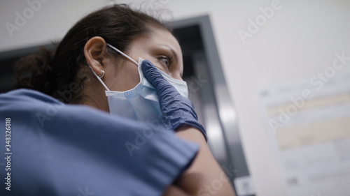Low angle shot of nurse checking mask during the coronavirus pandemic