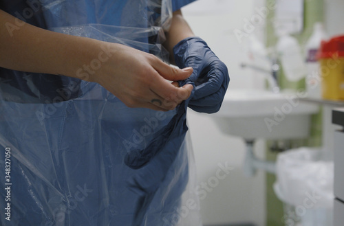 Photography Nurse putting on latex gloves in infection room for coronavirus protection