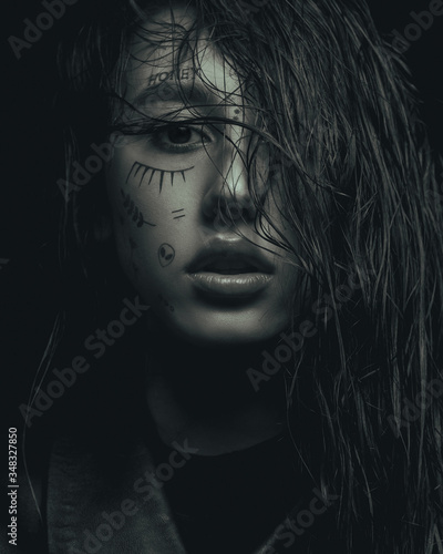 monochrome fashion portrait of a young girl  with drawings on her face