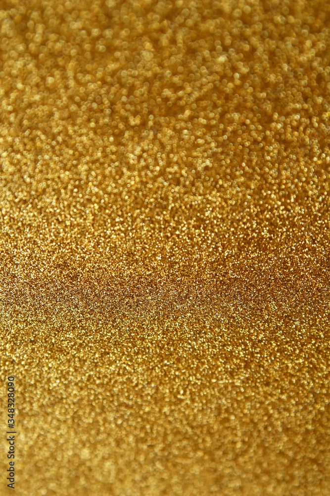 Gold glitter texture sparkling paper background. Abstract twinkled golden glittering background  with bokeh, defocused lights for Christmas holiday, banner, wedding invitation and greeting cards.