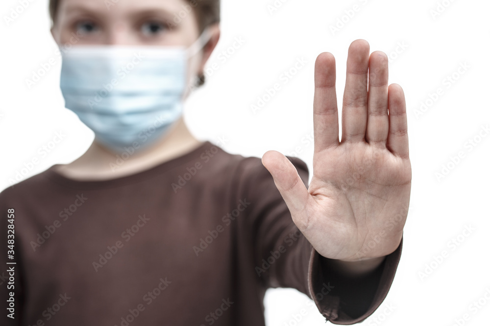 Child in medical mask put a palm in the stop sign. Child in medical mask put a palm in the stop sign.